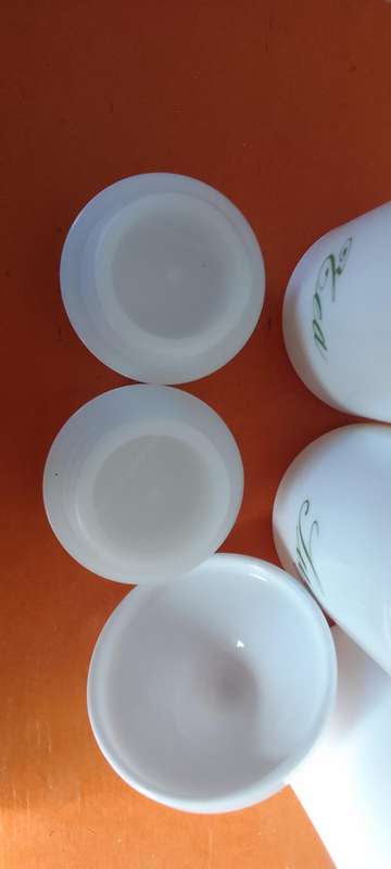 A Collection Of Milk Glass Containers With Lids