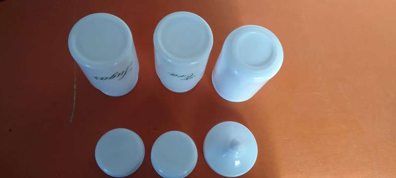 A Collection Of Milk Glass Containers With Lids