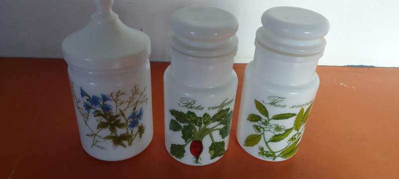 A Collection Of Milk Glass Containers With Lids