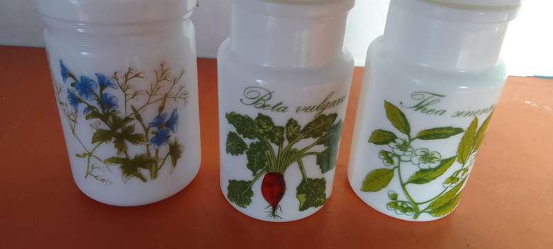 A Collection Of Milk Glass Containers With Lids