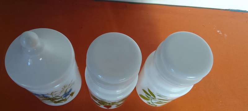 A Collection Of Milk Glass Containers With Lids