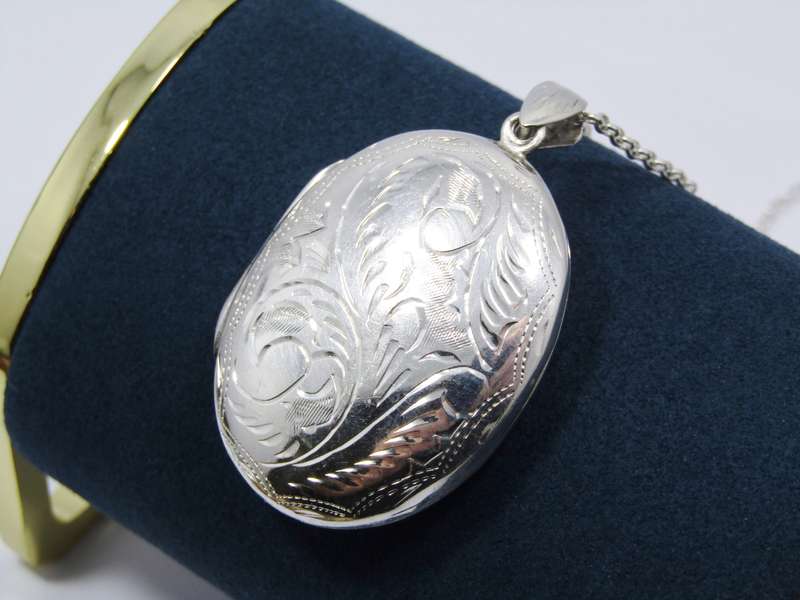 A Stunning Large Oval Engraved Locket On Chain in Sterling Silver.