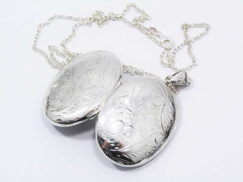 A Stunning Large Oval Engraved Locket On Chain in Sterling Silver.