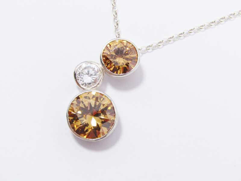 A Beautiful Orange And Clear Zirconia Pendant On Chain in Sterling Silver.
