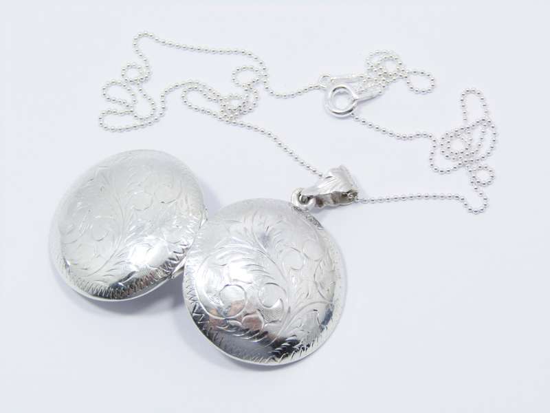 A Lovely Medium Size Engraved Locket on Chain in Sterling Silver.