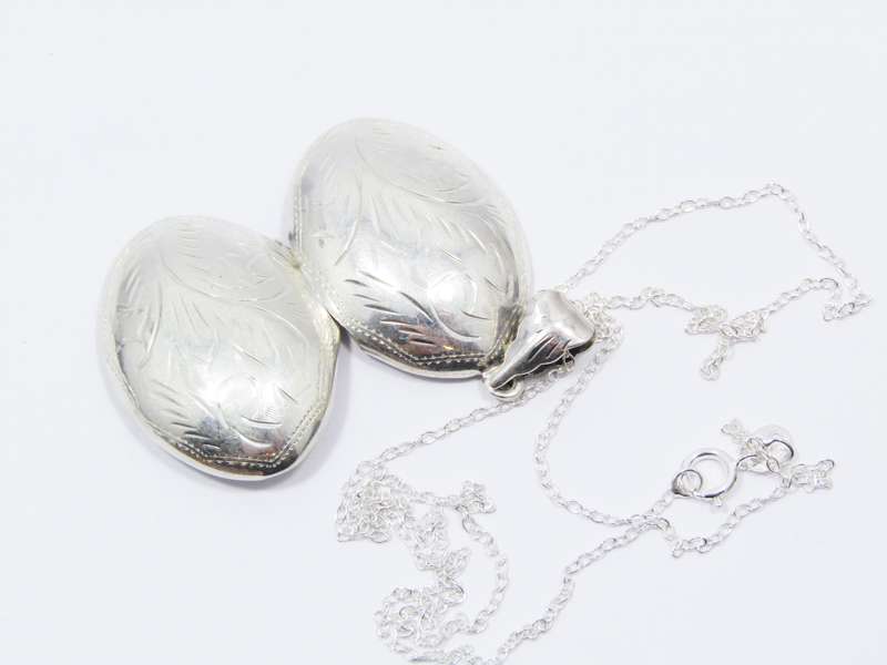 A Lovely Medium Size Oval Engraved Locket On Chain in Sterling Silver.