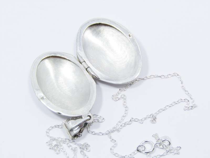 A Lovely Medium Size Oval Engraved Locket On Chain in Sterling Silver.
