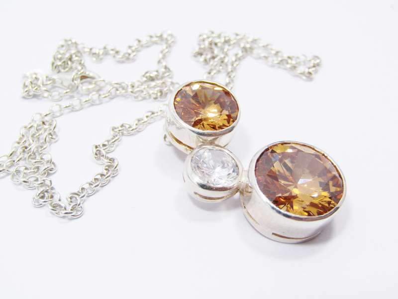 A Beautiful Orange And Clear Zirconia Pendant On Chain in Sterling Silver.