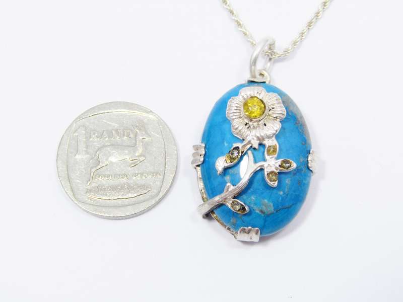 A Gorgeous Turquoise Color Stone Pendant With a Rose Detail on Chain in Sterling Silver