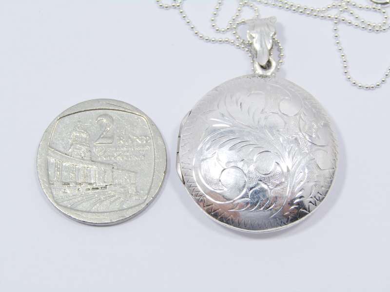 A Lovely Medium Size Engraved Locket on Chain in Sterling Silver.