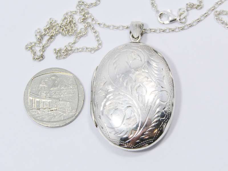 A Stunning Large Oval Engraved Locket On Chain in Sterling Silver.