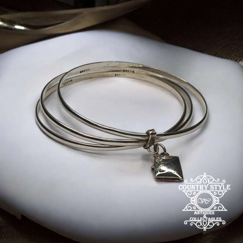 Trio of sterling silver bangles with a locket