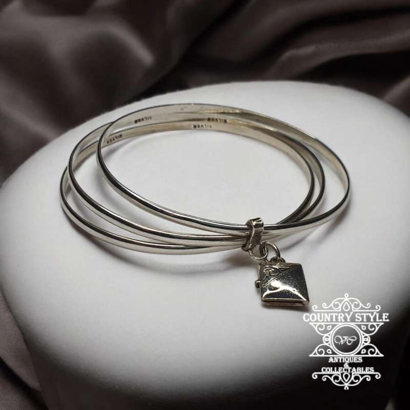 Trio of sterling silver bangles with a locket