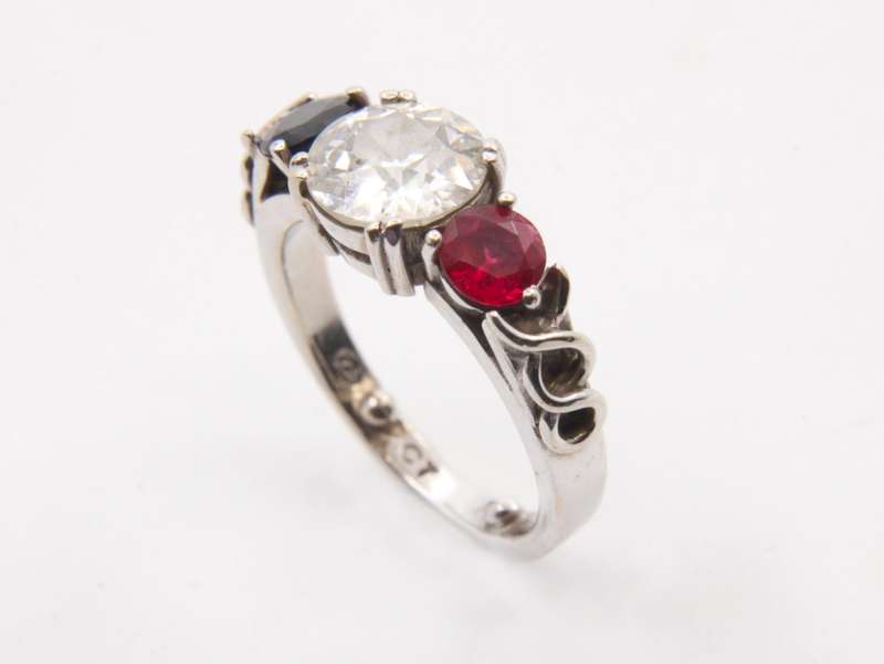 9CT GOLD RING SET WITH A 1.47CT DIAMOND AND FLANKED BY A RUBY & SAPPHIRE