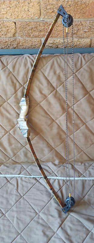 A camo compound bow with 9 arrows