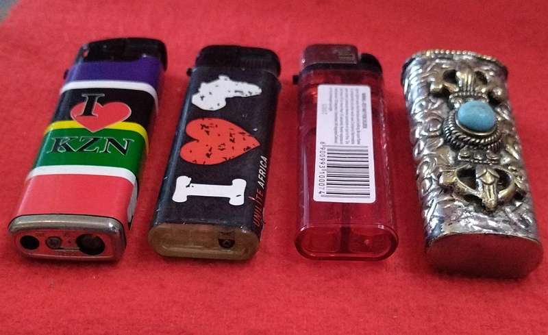 Assorted lighters (2 refillable) and a fancy metallic holder