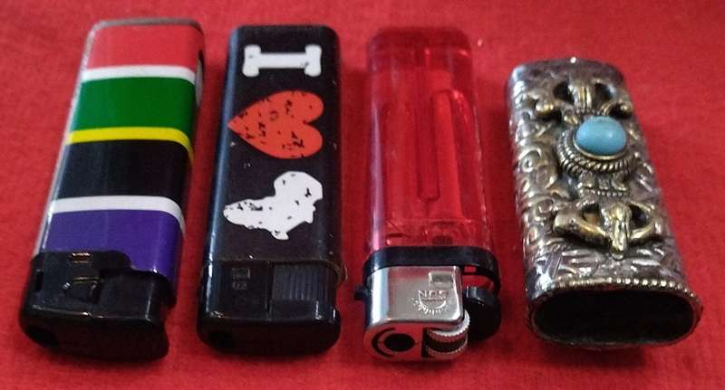 Assorted lighters (2 refillable) and a fancy metallic holder