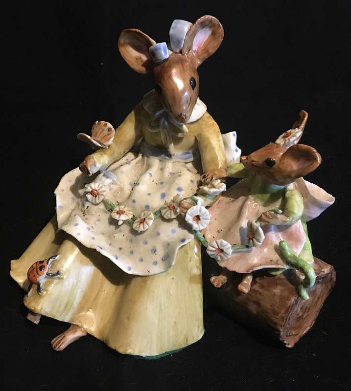Porcelain mother and baby mouse on a log