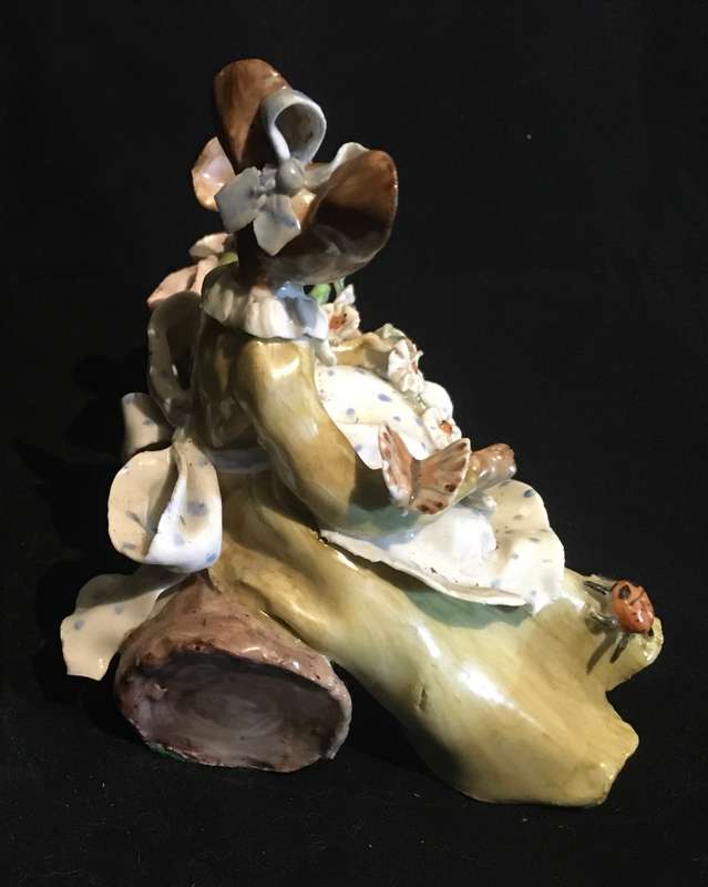 Porcelain mother and baby mouse on a log