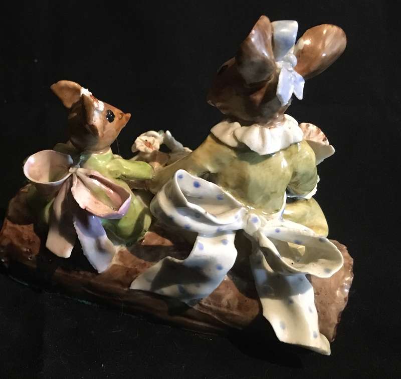Porcelain mother and baby mouse on a log