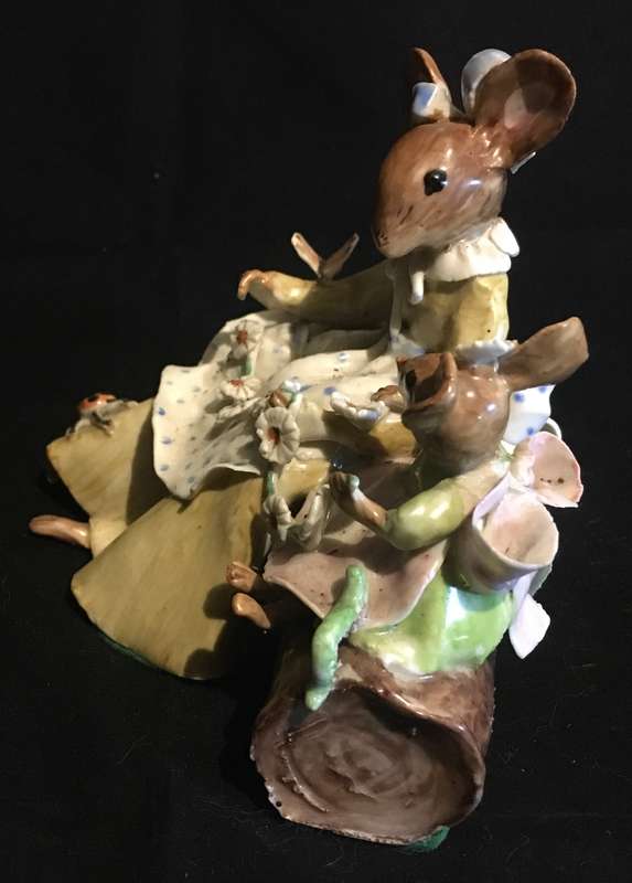 Porcelain mother and baby mouse on a log