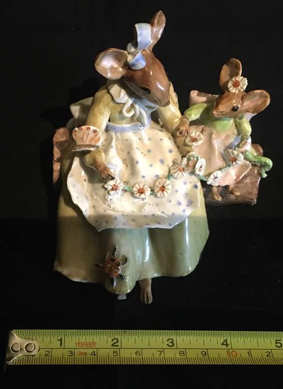 Porcelain mother and baby mouse on a log