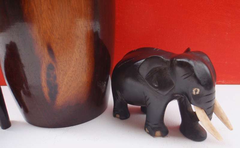 Beautifully carved wooden urn and two elephants .