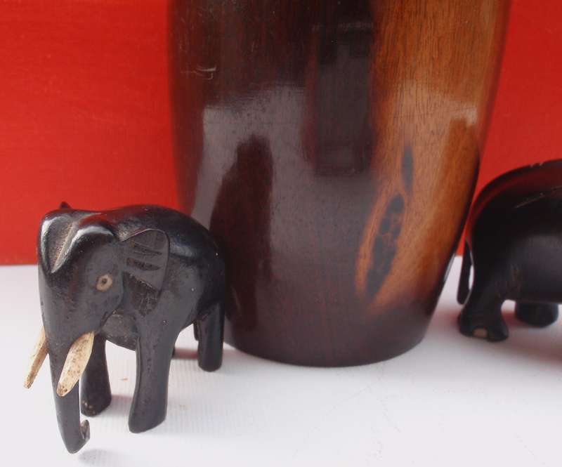 Beautifully carved wooden urn and two elephants .