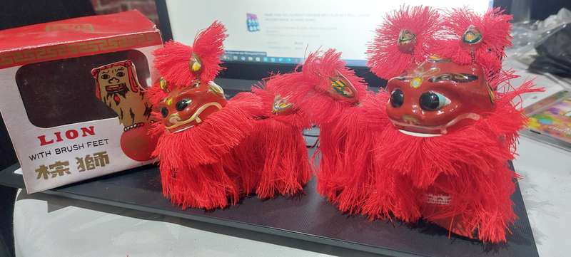VINTAGE NEW IN BOX PAIR OF CHINESE HAND PAINTED BOBBLE HEAD LIONS WITH BRUSH FEET.