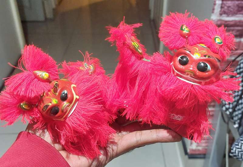 VINTAGE NEW IN BOX PAIR OF CHINESE HAND PAINTED BOBBLE HEAD LIONS WITH BRUSH FEET.