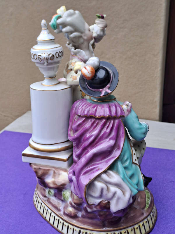 Porcelain stamped crown over M man courting lady