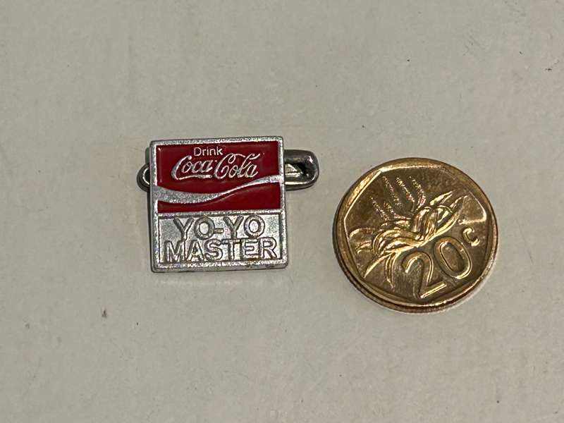 A metallic Coca Cola Coke Yo-Yo MASTER Badge