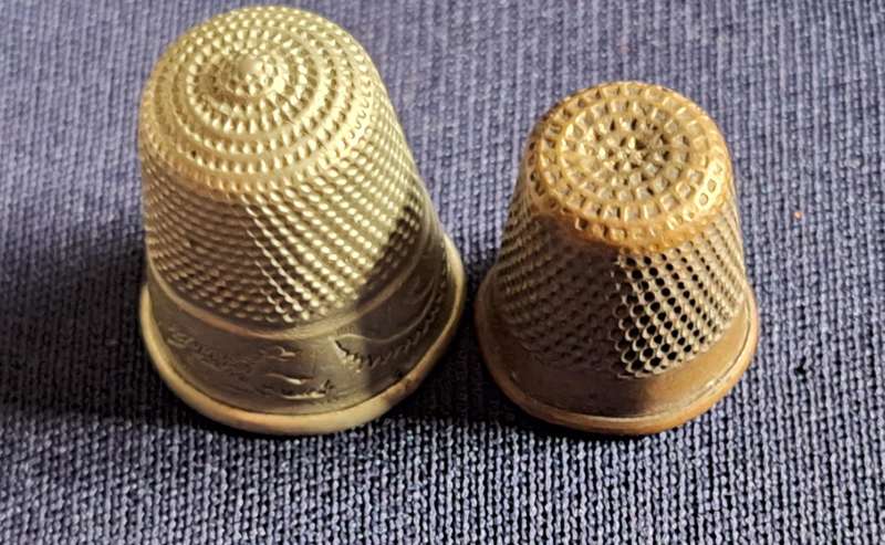 2 Metal Thimbles. Smaller has 4 on rim.  Larger Scroll design on rim.
