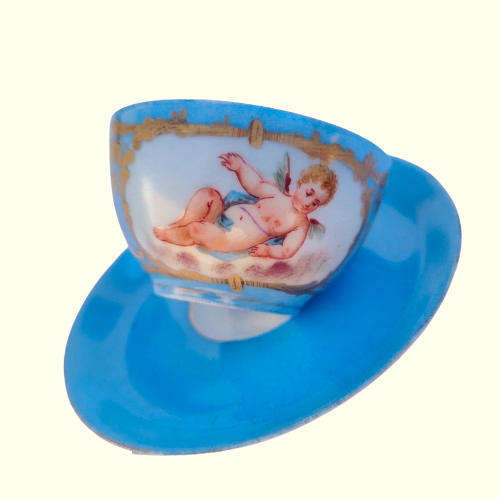 Lovely antique azure blue cherub cup and saucer in Sevres style.