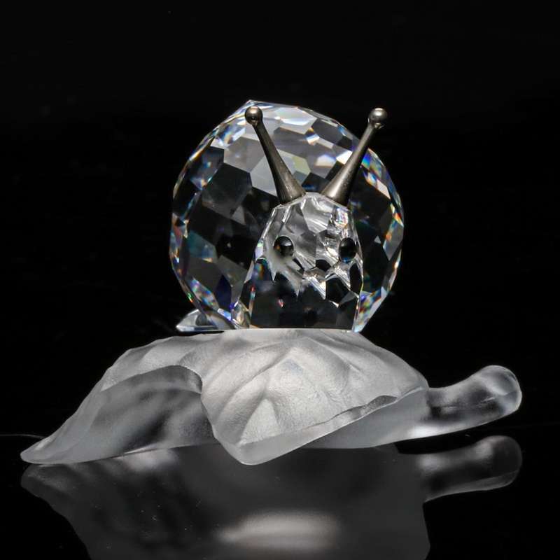 Swarovski Crystal Snail On A Vine Leaf Among Flowers and Foliage