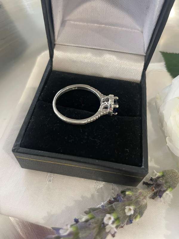 Sterling silver 925 ring featuring a blue gemstone, set in a 925 silver band with cubic zirconia's.