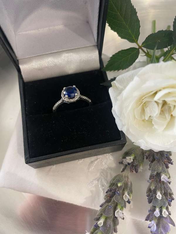 Sterling silver 925 ring featuring a blue gemstone, set in a 925 silver band with cubic zirconia's.