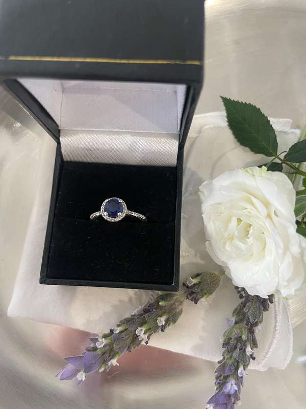 Sterling silver 925 ring featuring a blue gemstone, set in a 925 silver band with cubic zirconia's.