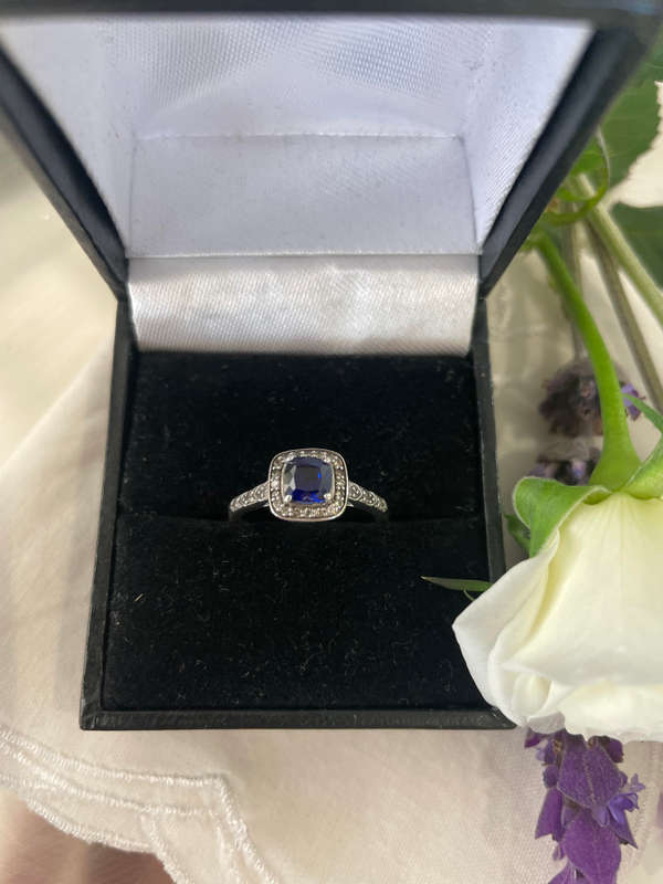 Sterling silver 925 ring featuring a blue gemstone, set in a 925 silver band with cubic zirconia's.