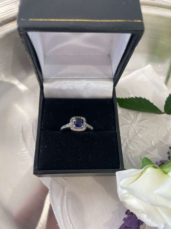 Sterling silver 925 ring featuring a blue gemstone, set in a 925 silver band with cubic zirconia's.