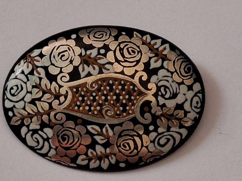 Oval enamelled and painted metal brooch