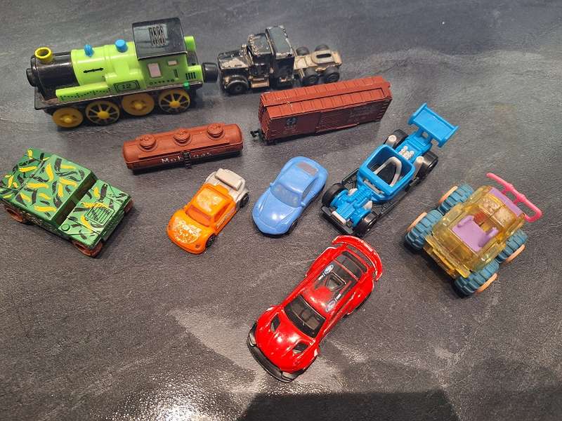 Collection of Hotwheels cars and unmatched train pieces