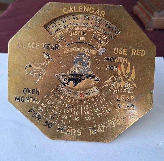 Vintage brass 50 year perpetual calendar, depicting the Voortrekker monument