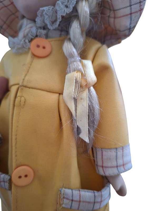 Vintage porcelain doll dressed for the rain with stand