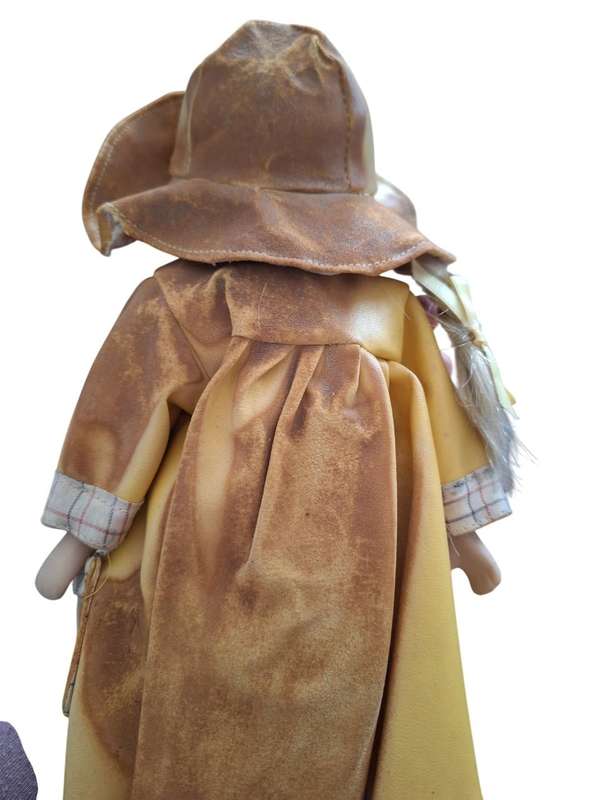 Vintage porcelain doll dressed for the rain with stand