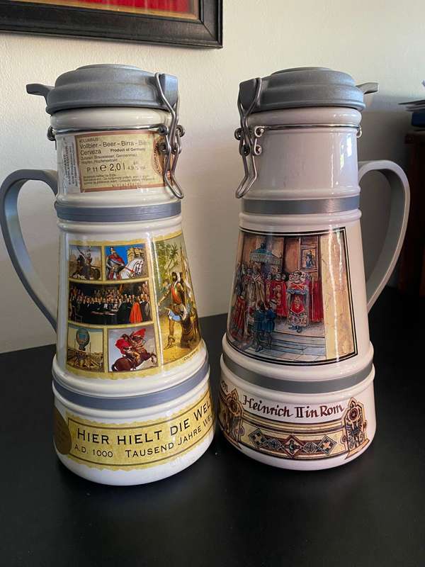 TWO VERY LARGE GERMAN,LIDDED BEER STEINS-PORCELEIN AND STILL SEALED (CONTENTS CANNOT BE GUARANTEED)L