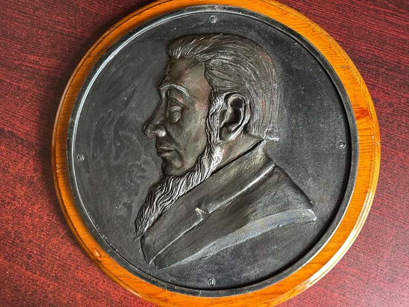 ANTIQUE IRON EMBOSSED SIDE PROFILE OF PRESIDNT PAUL KRUGER ON WOODEN BASE-HEAVY-DIAMETER 35,5 CM