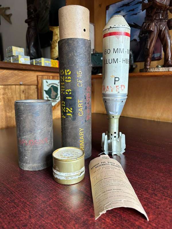 60 MM illuminating bomb type 62 in complete condition ,with range table and holder. Inert