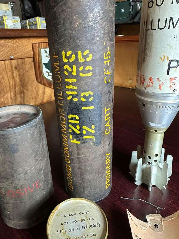 60 MM illuminating bomb type 62 in complete condition ,with range table and holder. Inert