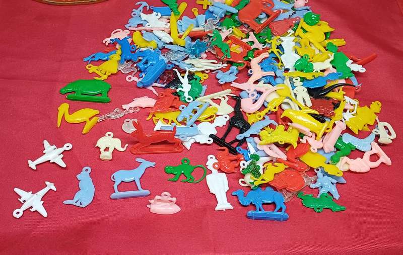 Collectable tin full of vintage plastic charms